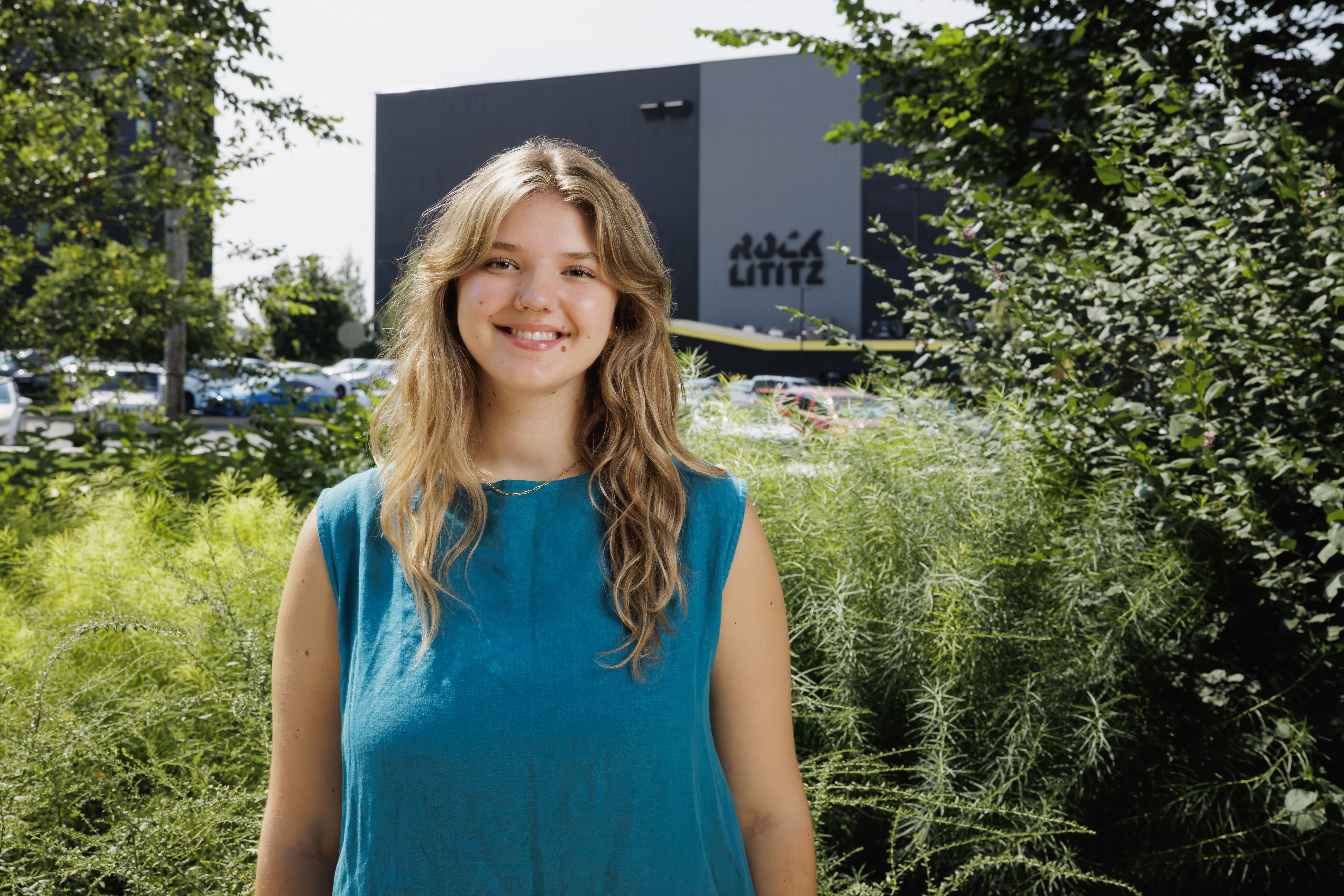 Student smiling in front of building