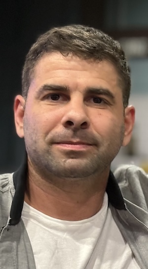 headshot of Nick looking into the camera wearing grey sweatshirt