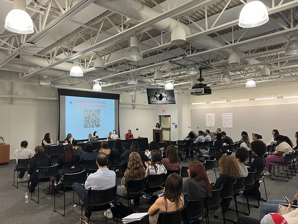 a panel of speakers addresses the seated audience