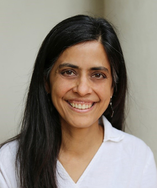 Female with long brown hair broadly smiling 