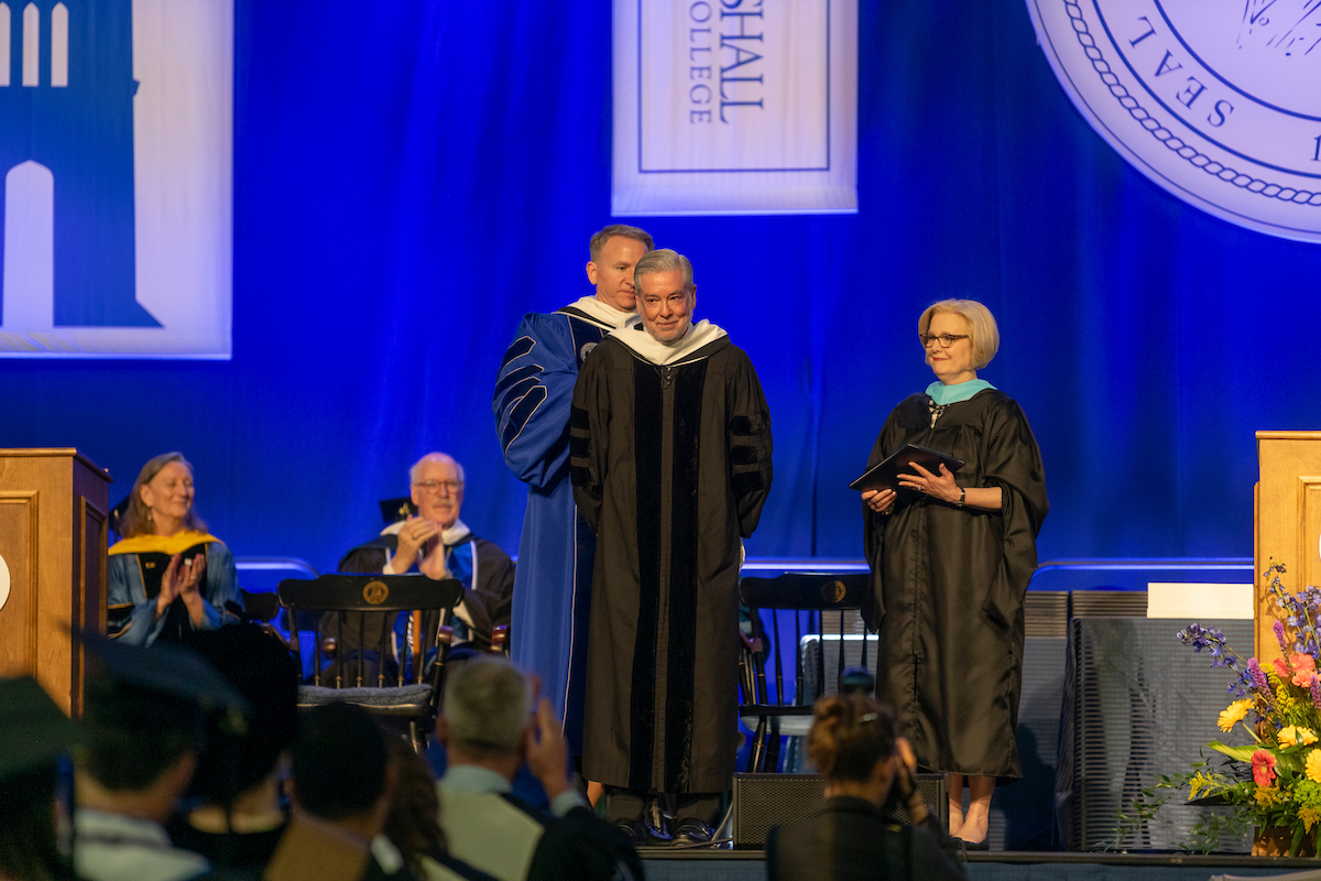 John Fry pictured, about to get hooded to receive an honorary degree.