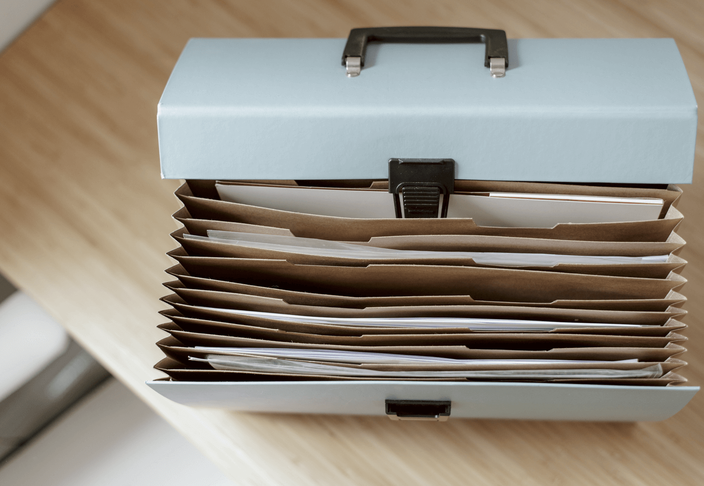 A bluebrief case, open, showing papers and files inside