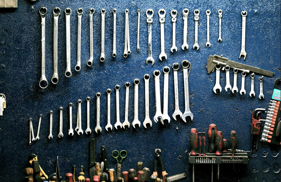 A wall of wrenches and other tools in a workshop