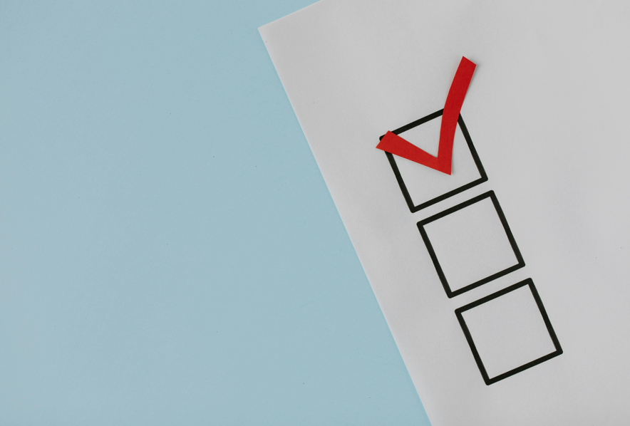 3 black boxes in a column on a piece of paper; the top box has a red checkmark 