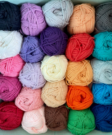 Five rows of yarn in a variety of colors.