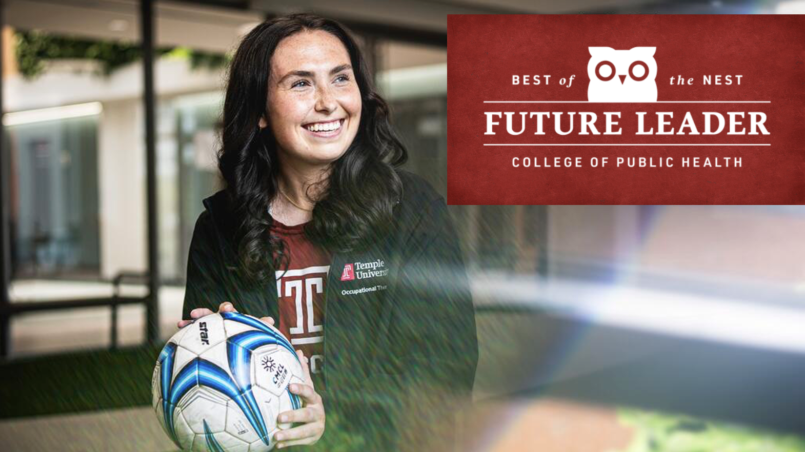 Student holding soccer ball and smiling.