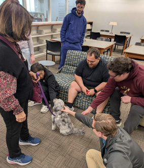 Happy health sciences students petting one of the therapy dogs. 