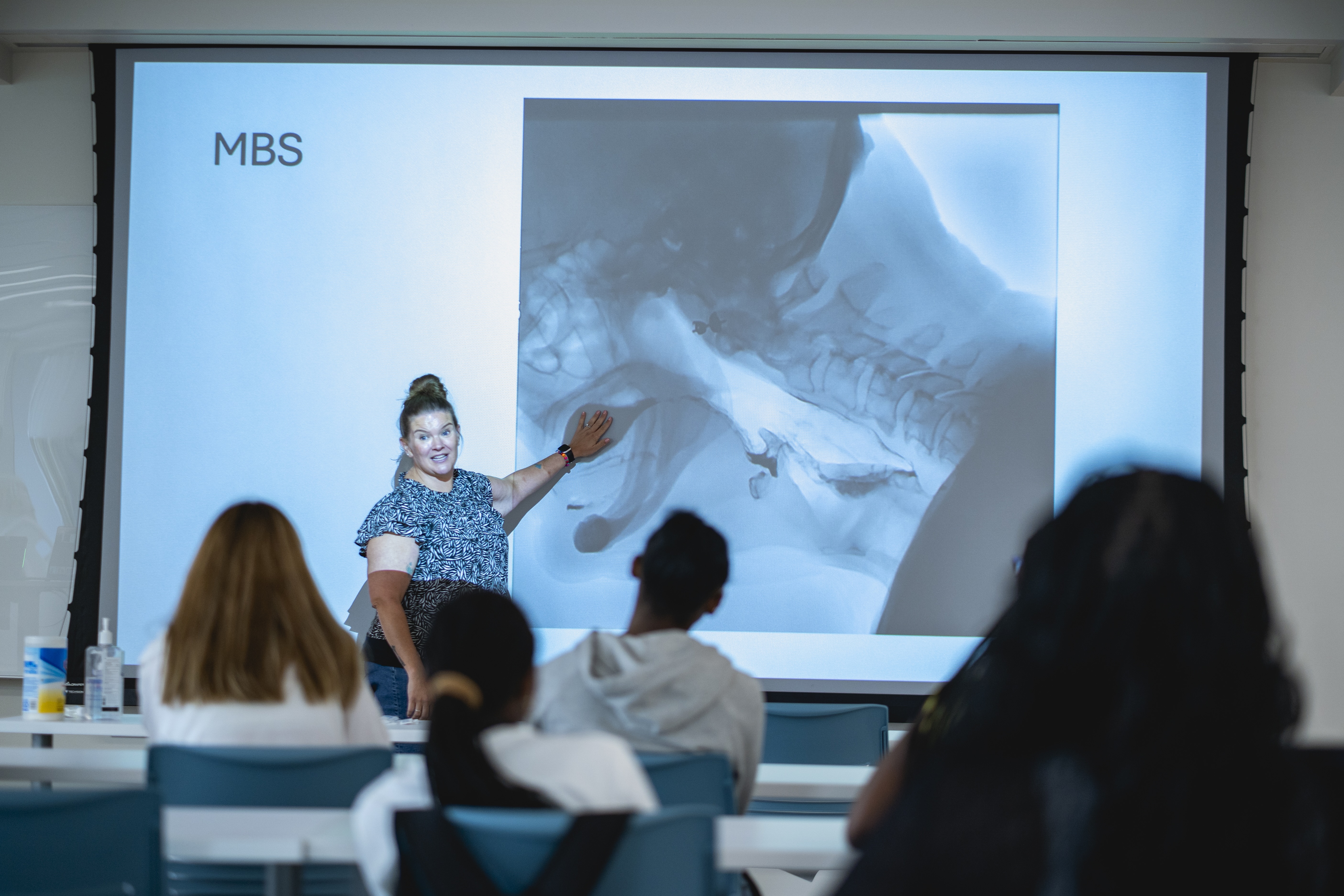 A guest speaker in the pre-college institute introduces students to the work of a medical speech-language pathologist.