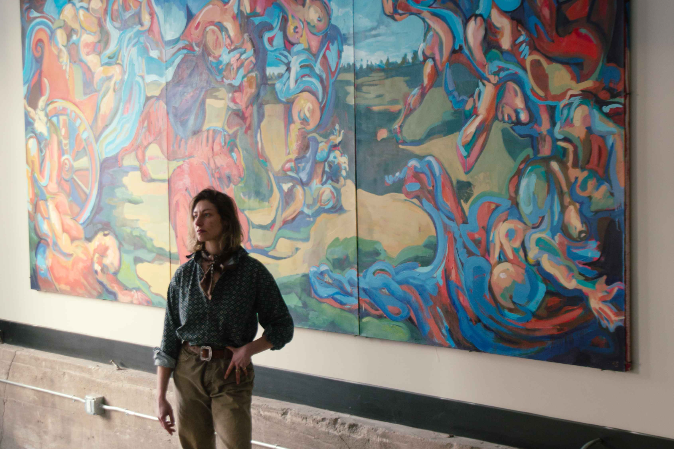 Lia Strasser standing in front of a 15-foot painting, inspired by the ceiling at the Caracci Galleria, that she made while studying in Rome called “Ariadne’s Dream.” Photographer: Juliette Hermant, 2025.