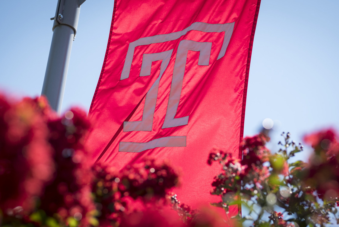 A photo of the Temple flag with flowers.