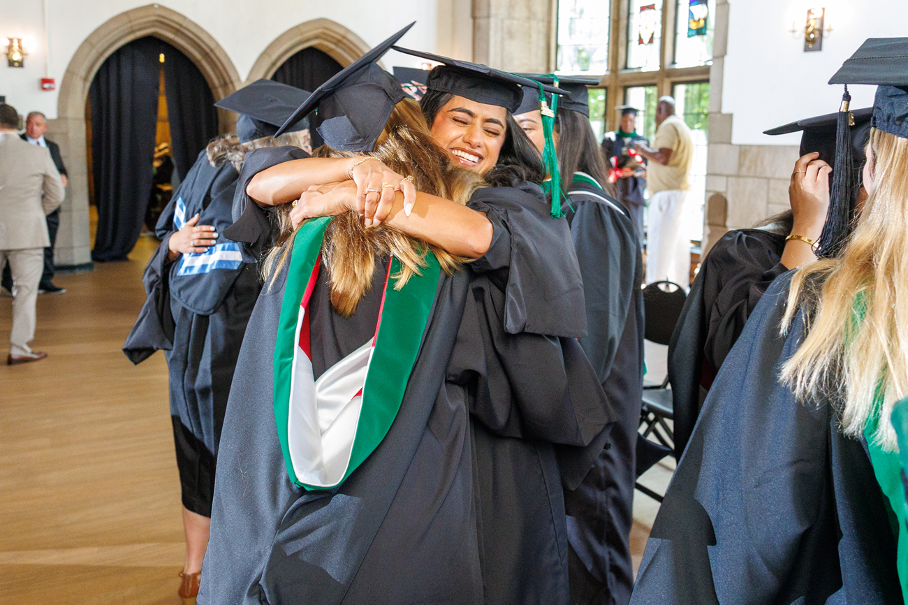Image of smiling students hugging at PA graduation in Mitten Hall.