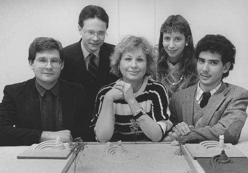Archival photo of Brigitte Knowles sitting at a table with four other architects