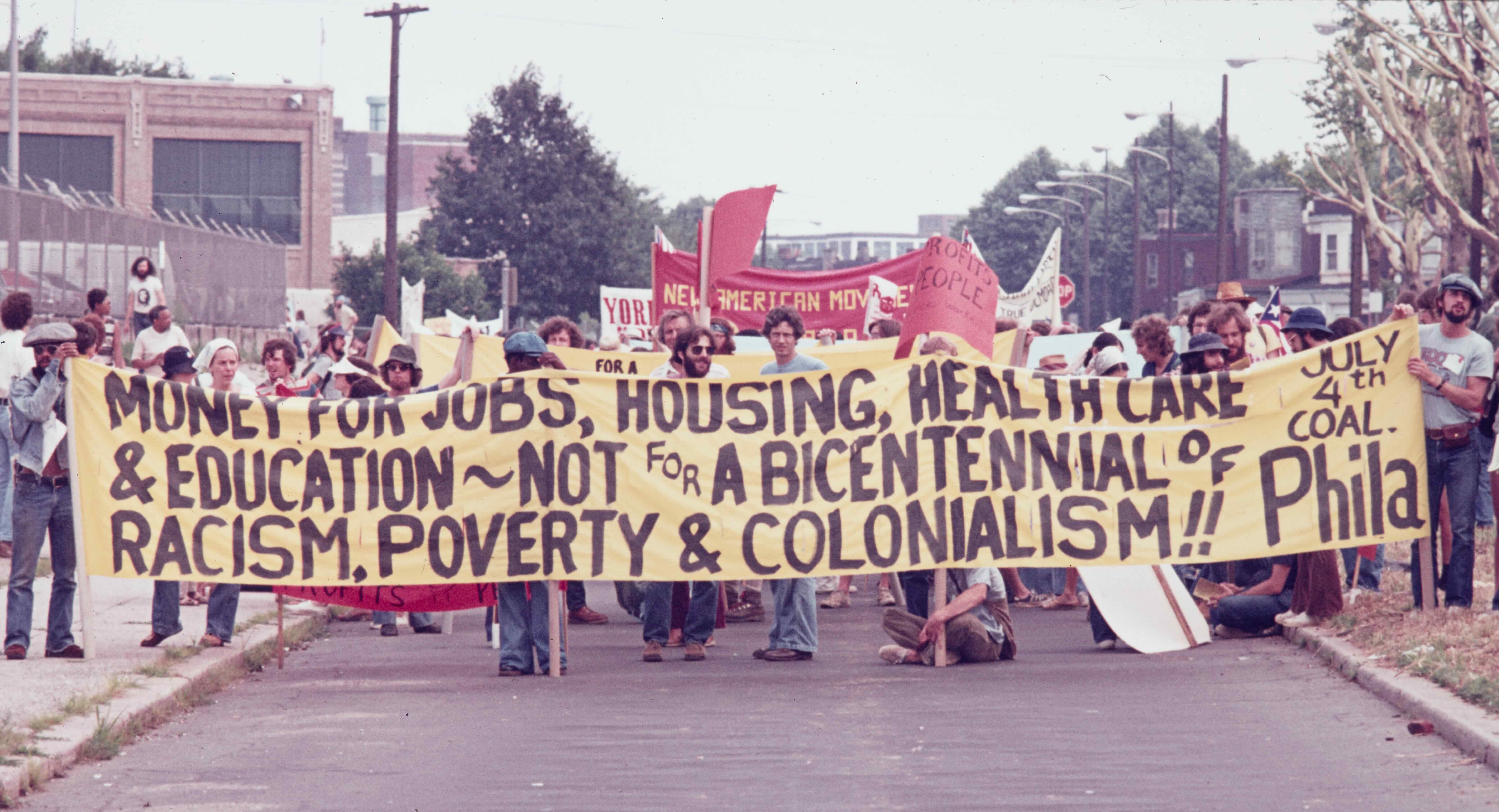 photograph of protesters holding up a large banner