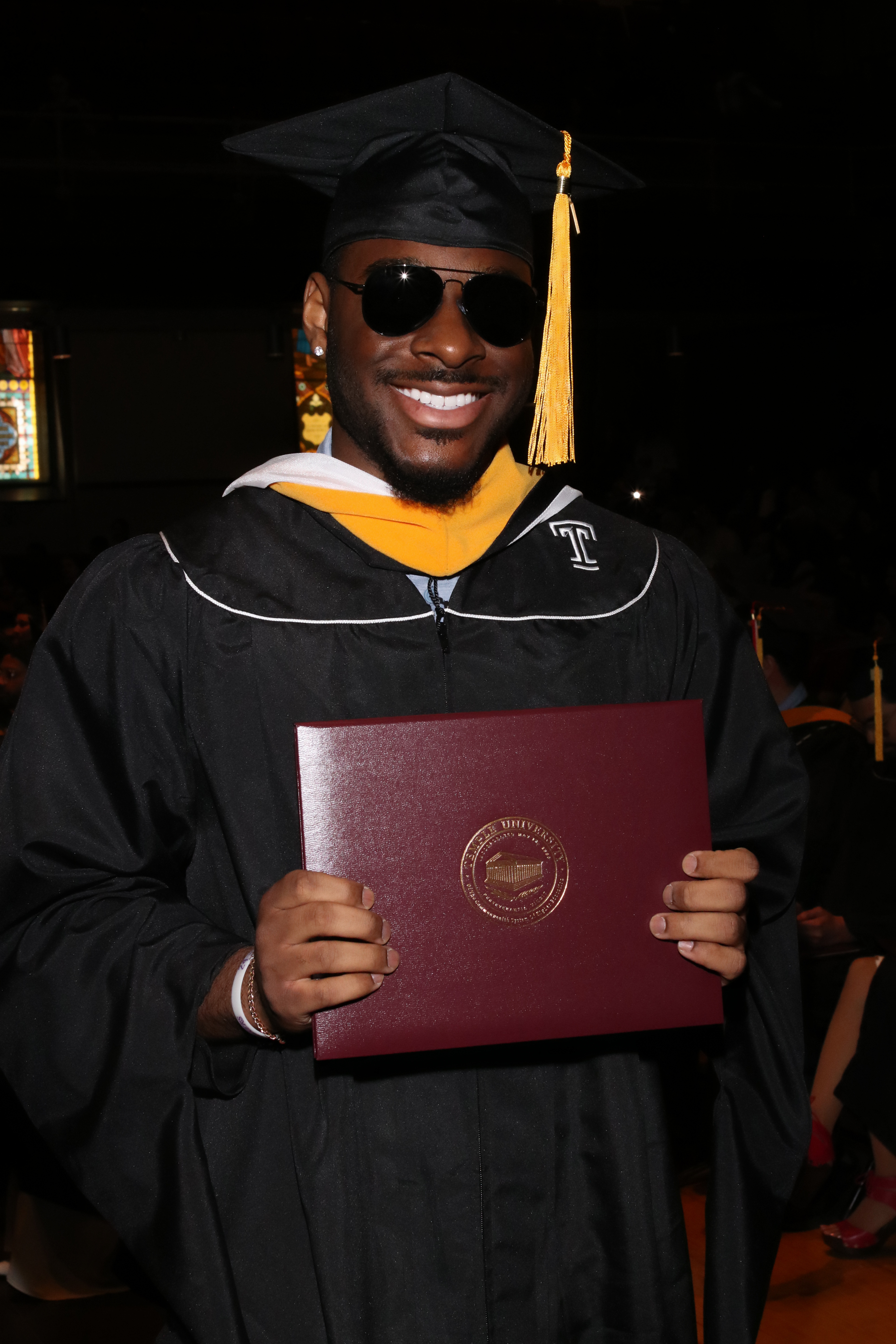 Daniel in his cap and gown after receiving his PSM.
