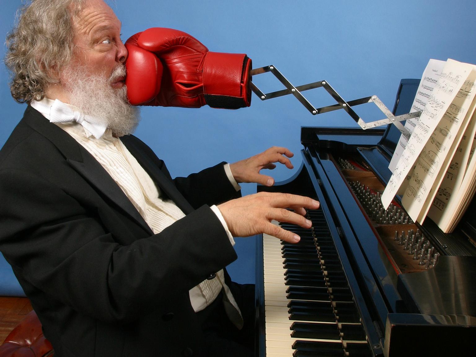 piano with boxing glove satirically punching the player