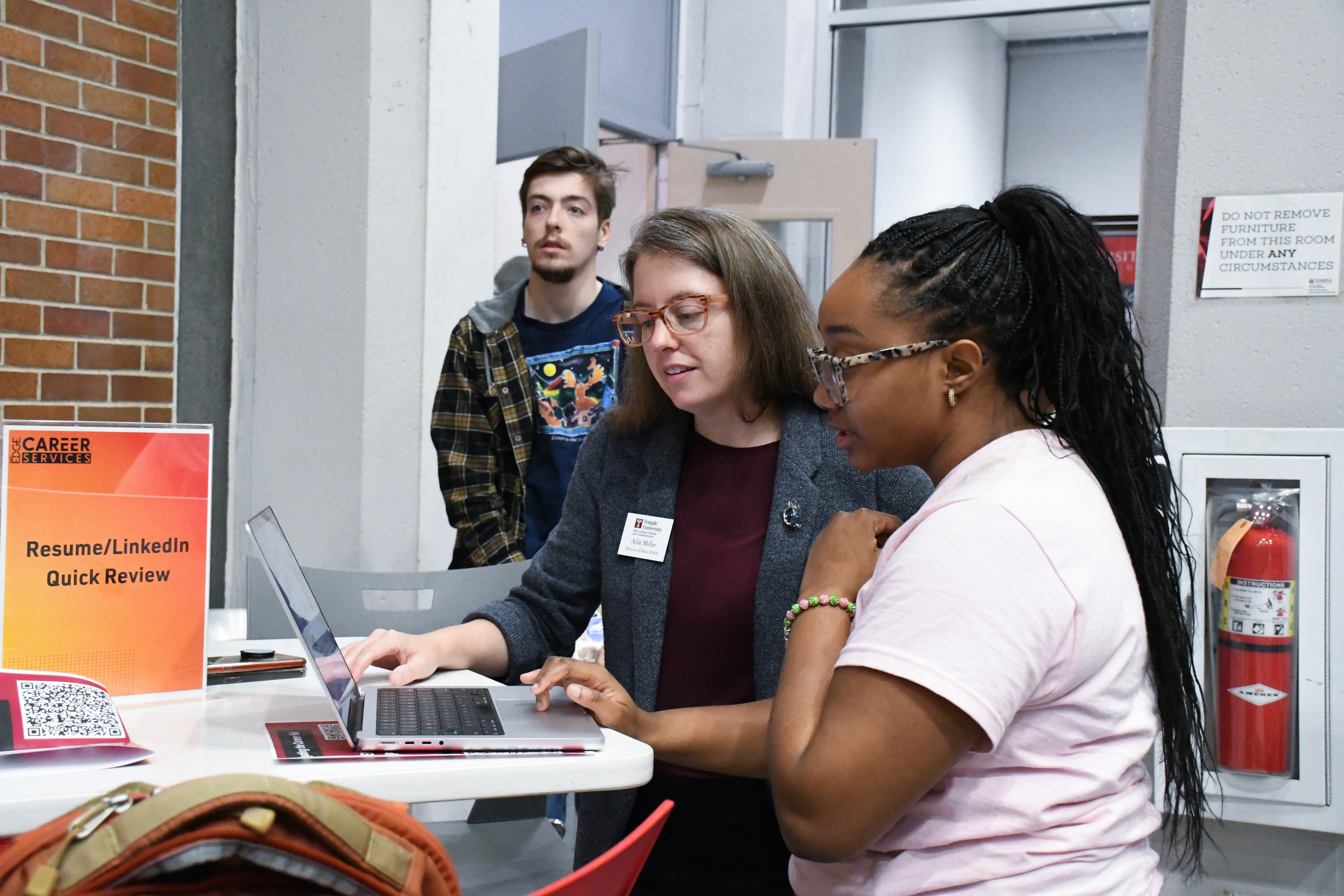Student and staff looking at laptop
