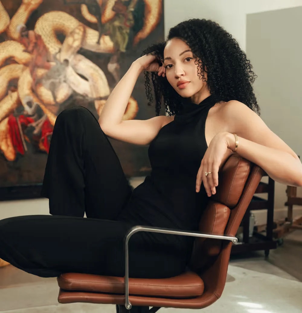 Harmonia Rosales, an Afro-Cuban artist, photographed in front of a painting.