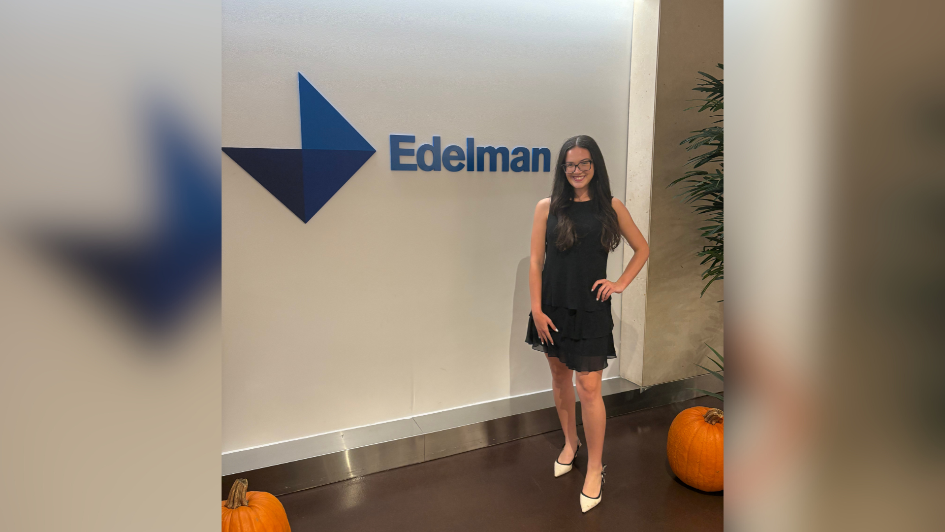 Student standing in front of Edelman sign