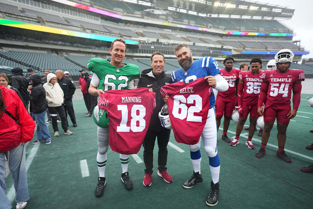 Image of Peyton Manning and Jason Kelce with Temple football at Lincoln Financial Field.