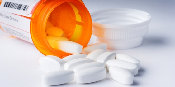 Prescription pills spilling out of a prescription bottle.