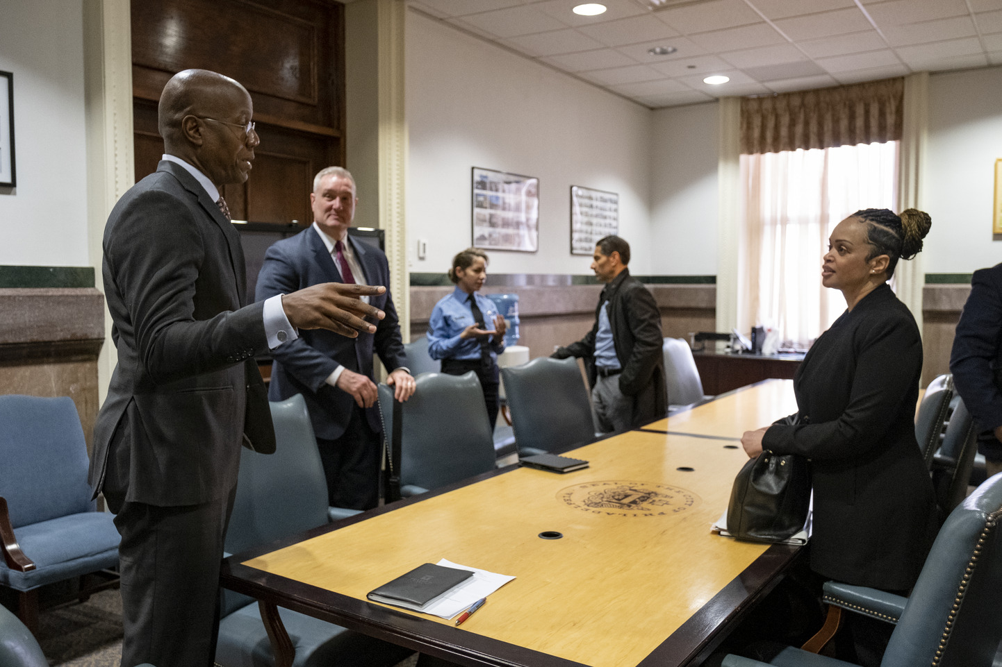 President Wingard speaks with Commissioner Outlaw at a long table