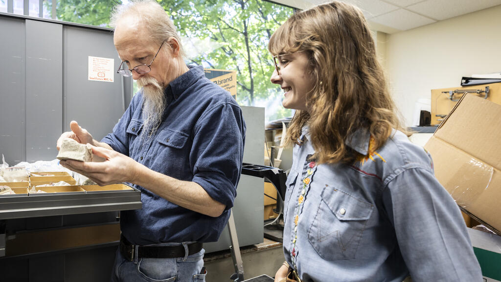 Image of of Terry and Shreero sorting through fossils in Terry's office.