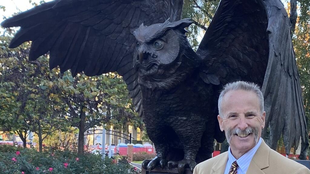 Dave Deveraux stands next to the Owl statue on Temple's main campus.