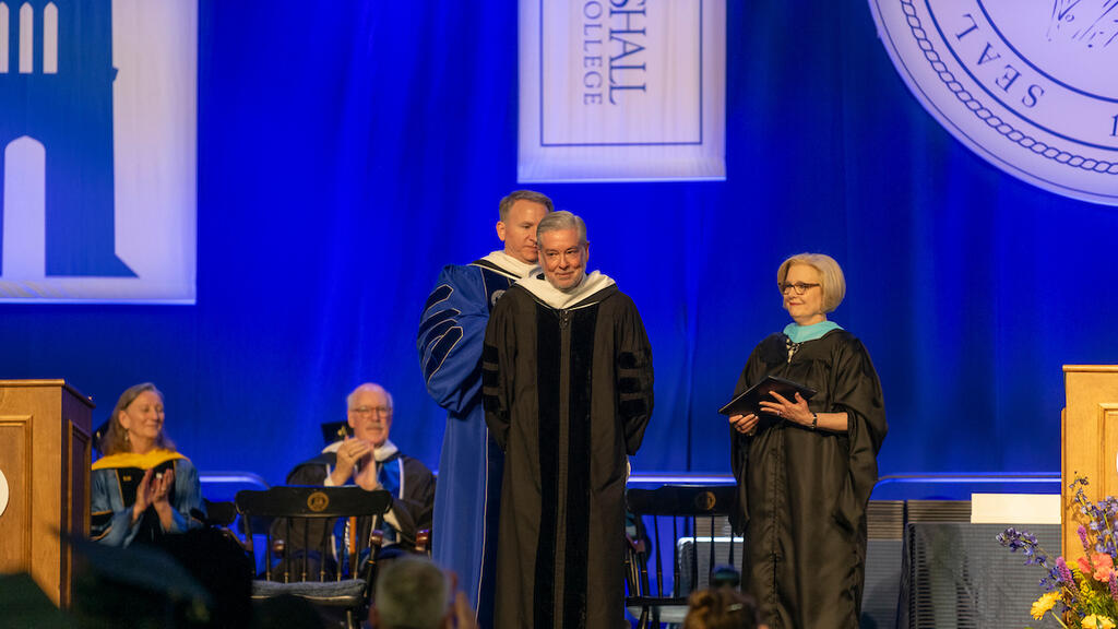 John Fry pictured, about to get hooded to receive an honorary degree.