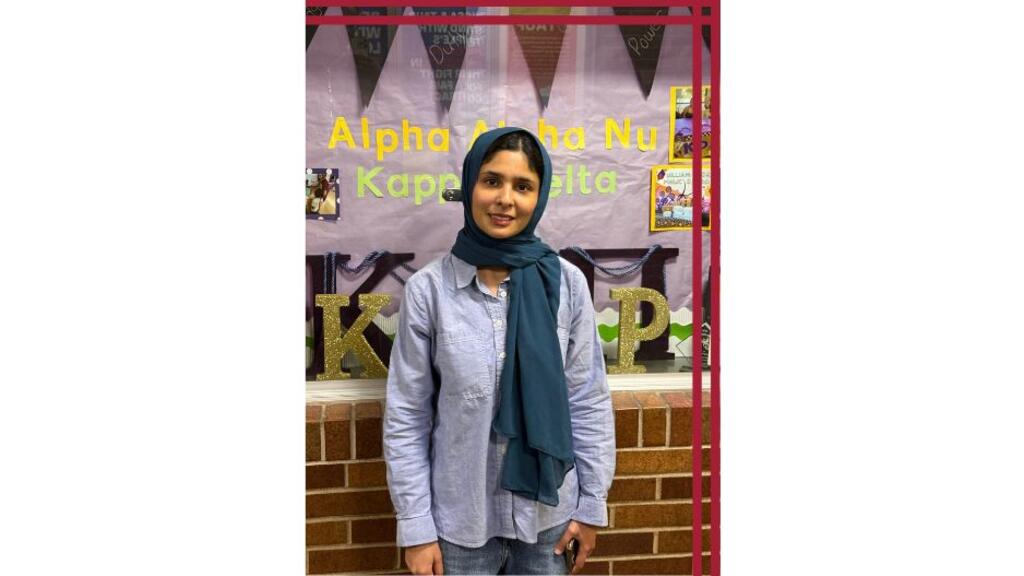 A student stands in front of a decorative display