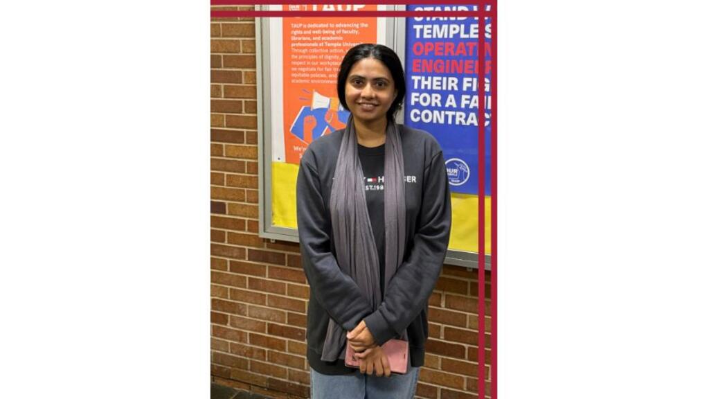 A student stands in front of a bulletin board