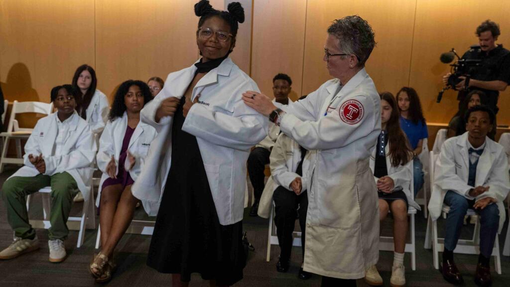 Seventh grader Madison Miller receives her white coat from Dean Goldberg on Temple's campus.