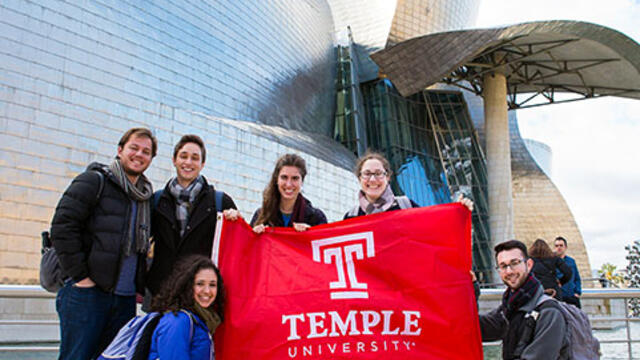 Students standing in Spain with TU flag