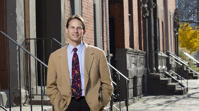 Mark Salzer standing in front of rowhomes.