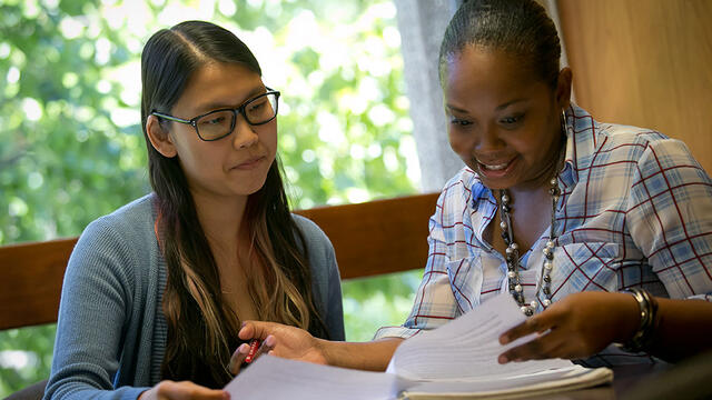 A student receiving guidance from a Temple employee.