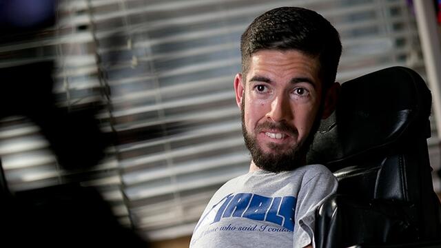 A man in a wheelchair wearing his [dis]ABLE brand T-shirt.