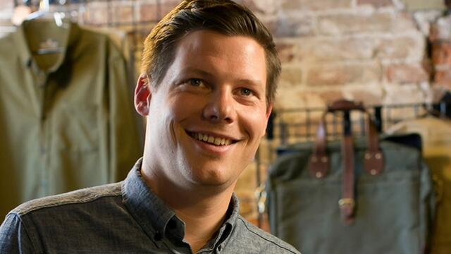 Brian Linton sitting among United by Blue apparel.