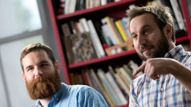Two male Temple alumni working in their graphic design studio.