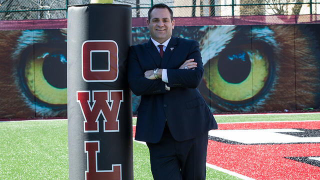 Patrick Kraft leaning against a pole on Temple s practice football field.