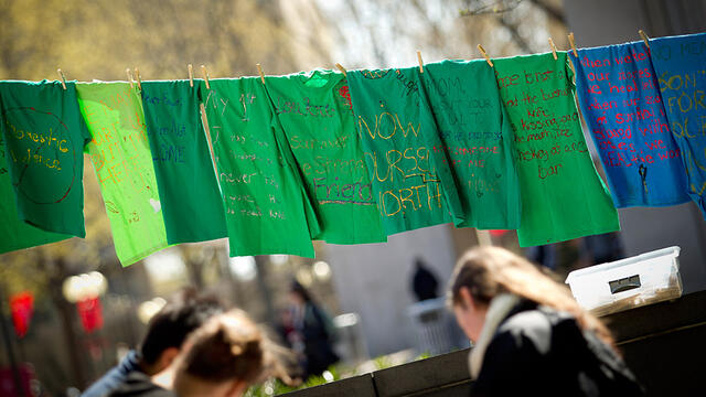 Green t-shirts with messages hanging from a clothesline in Founder s Garden.