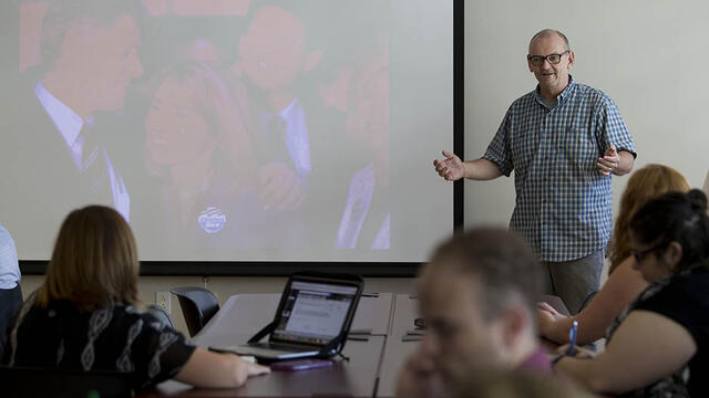 Jim Macmillan talking to students in a classroom.