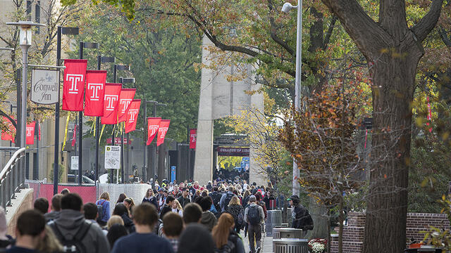 A crowd of students walking on Polett Walk towards the Bell Tower.