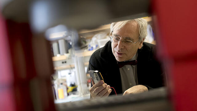 Peter Lelkes looking at a device in the lab.