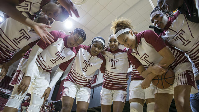 The women s basketball team having a team huddle.