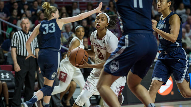 A woman basketball player with a ball in her hands.