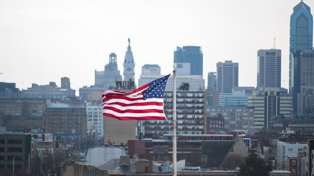 Image of an American flag in front of the Philadelphia skyline.