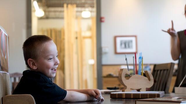 Mark Ovington, 5, sitting in his adaptive chair made of cardboard