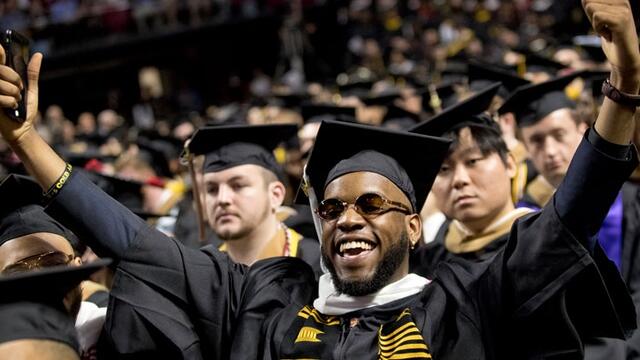 A graduate celebrating at Temple s Commencement