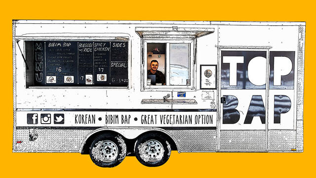 A still image of a man behind the Top Bap food truck.