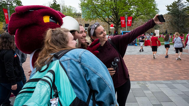 Students taking a selfie with Temple mascot Hooter
