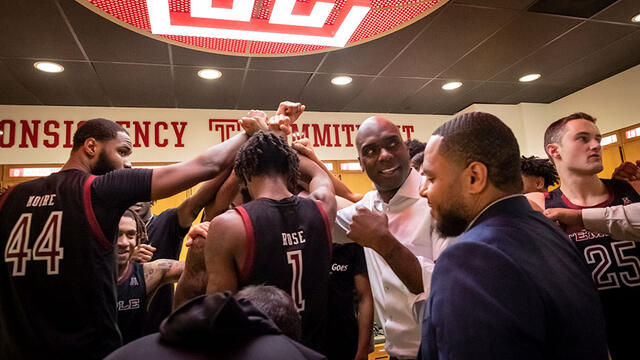 Aaron McKie and coaches, players huddle